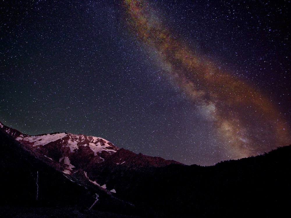 photographie d'un ciel étoilé au-dessus d'une montagne